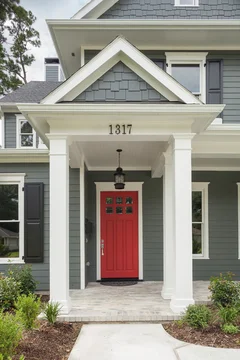 Red front door with dark gray siding